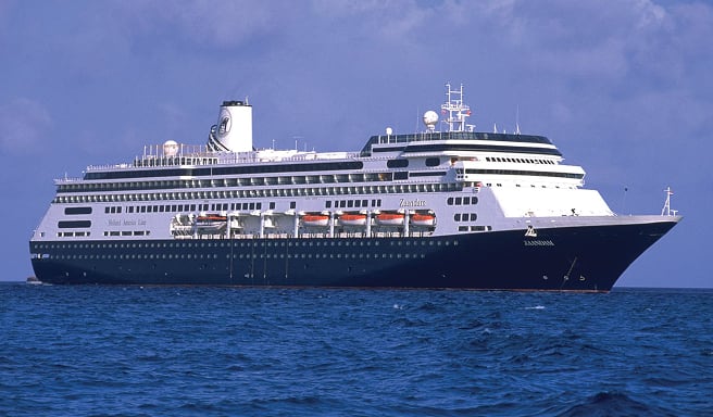 Blue Ocean Cruise Ship at Sea A sleek, modern cruise ship with a dark blue and white color scheme sailing on blue ocean waters under a cloudy sky. The vessel appears to be a mid-sized Holland America Line ship.