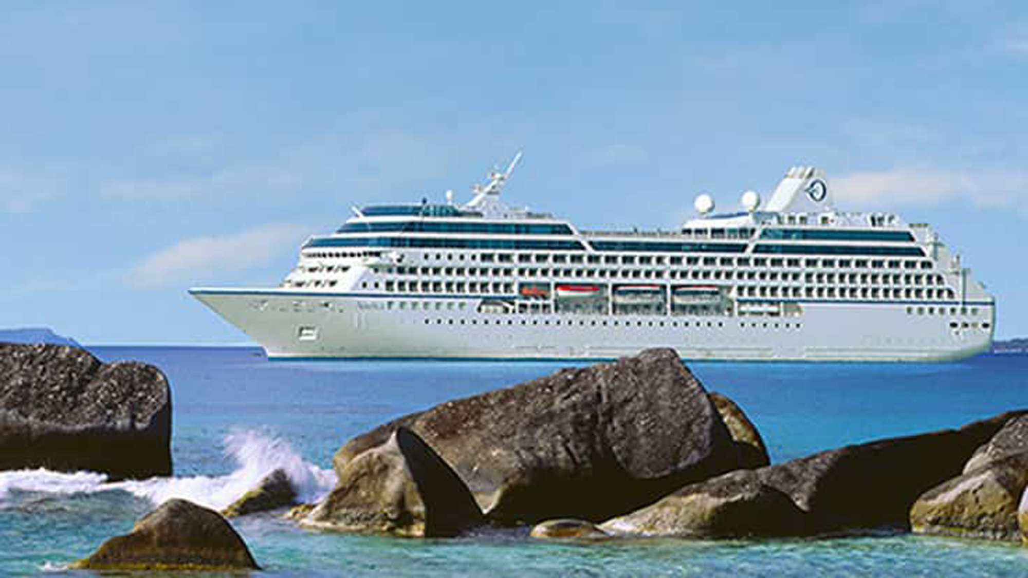 Cruise Ship Sailing Past Rocky Coastline A white and blue cruise ship sailing on turquoise waters near large rocky formations in the foreground. The ship is set against a clear blue sky, creating a serene maritime scene.