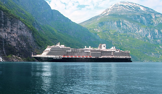 Cruise Ship in Norwegian Fjord A modern cruise ship sailing through a stunning fjord with steep green mountainsides and snow-capped peaks in the background. The calm blue water reflects the vessel and surrounding landscape.