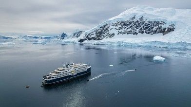 Expedition Cruise Ship in Antarctic Waters A sleek expedition cruise ship navigating through remote polar waters, showcasing the purpose-built design and ice-class capabilities typical of Swan Hellenic's fleet.