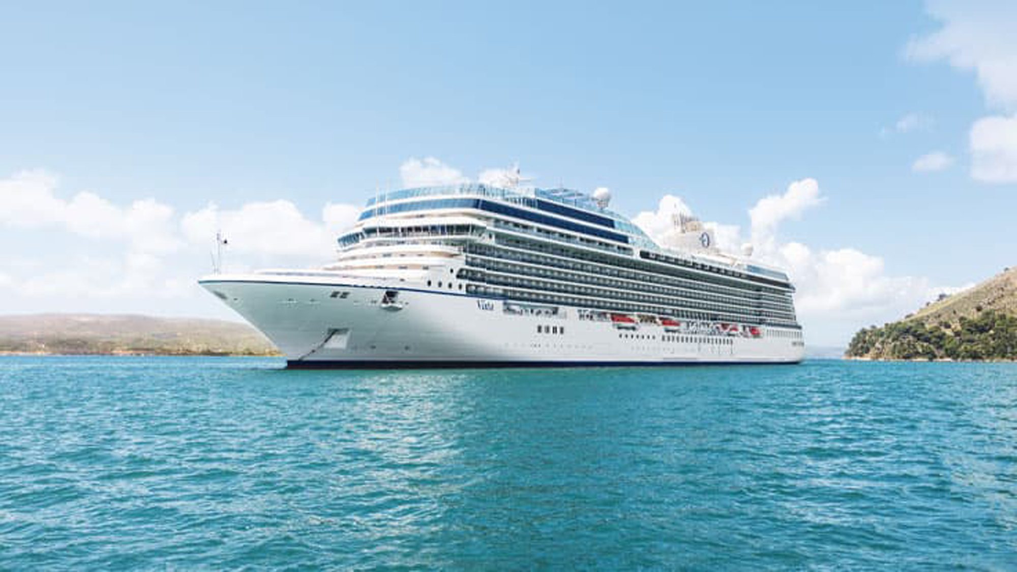 Luxury Cruise Ship in Turquoise Waters A pristine white and blue cruise ship anchored in crystal-clear turquoise waters near a rocky