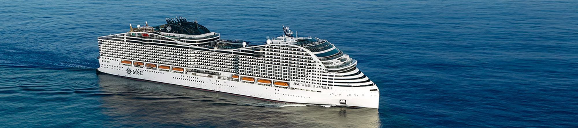 MSC World America Cruise Ship at Sea A large, modern MSC cruise ship sailing on calm blue waters, showcasing its sleek white design with multiple decks and distinctive exterior features.