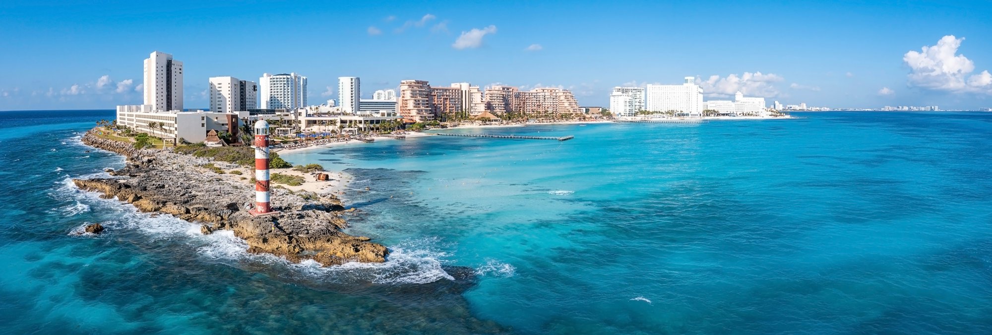 Vibrant Mexican beachfront scene with colorful umbrellas, turquoise water, and a cruise ship visible in the harbor