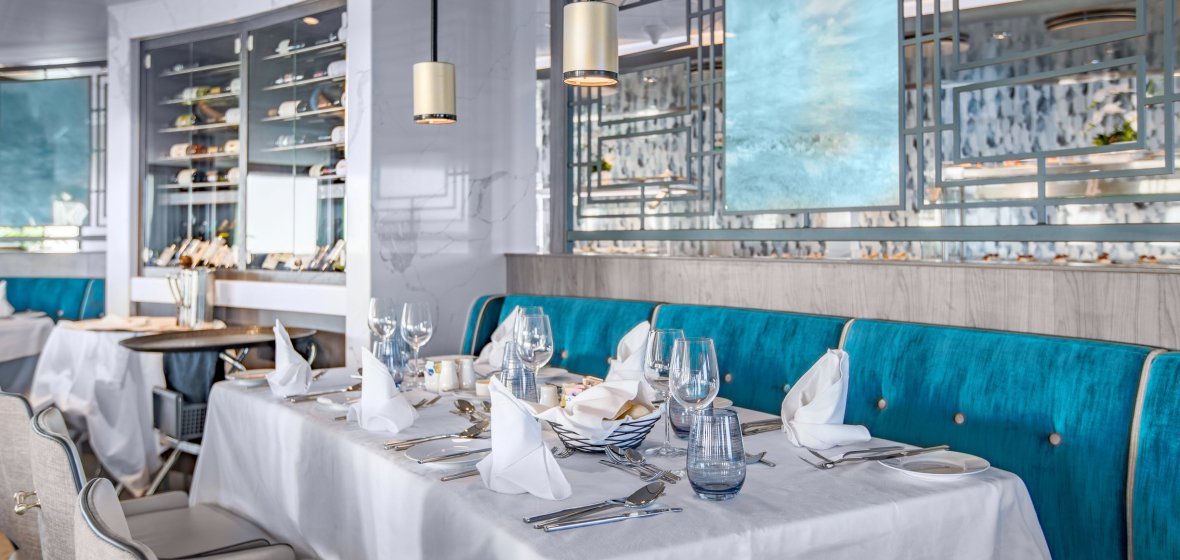 Elegant Fine Dining Restaurant with Ocean Views Elegant fine dining restaurant aboard an expedition cruise ship with ocean views through large windows.