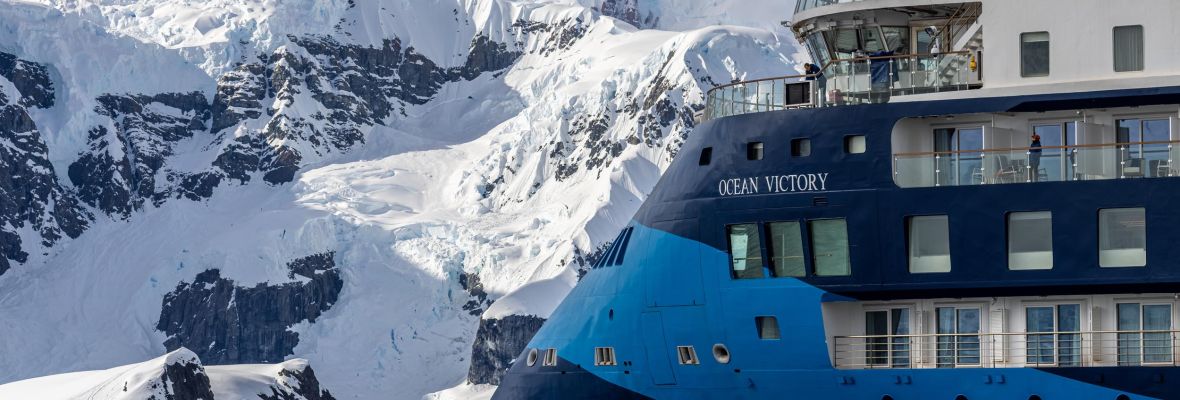 Ocean Victory Cruise Ship in Antarctic Paradise Bay Ocean Victory cruise ship navigating through icy Antarctic waters surrounded by glaciers and snow-covered mountains in Paradise Bay.